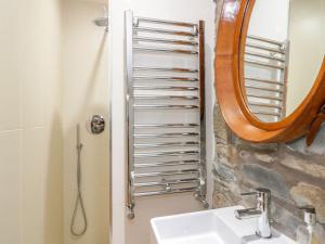 un bagno con lavandino e doccia con specchio di Wee Cottage a Moffat Altre 6 foto