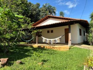 a house with a hammock in front of it at Pousada Rio das Almas in Pirenópolis