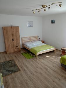 a bedroom with a bed and a wooden cabinet at Baza Noclegowa ARKADIA in Świnoujście