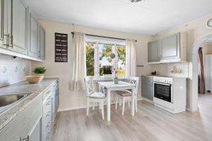 a kitchen with a table and chairs and a window at Charm house by Vormsund by Oslo airport in Årnes +29 photos