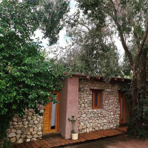 a small stone house with a stone wall at Las cuatro estaciones in Merlo
