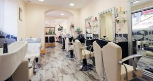 a hair salon with white chairs and a sink at Hotel Internazionale Bellinzona in Bellinzona