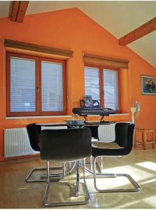 ブレッドにあるMorning sunshineの椅子とテーブルと窓のあるオレンジ色の部屋