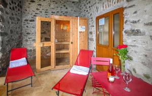 a red table and chairs in a room with a door at Pet Friendly Home In Privas With Sauna in Privas +21 photos