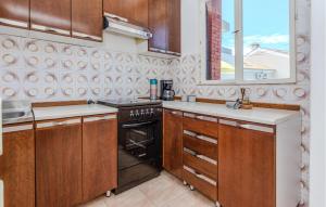 a kitchen with wooden cabinets and a stove top oven at Stunning Apartment In Nin With Wifi in Nin