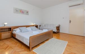 a bedroom with a large bed and a couch at Stunning Apartment In Nin With Wifi in Nin