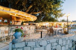 a restaurant with tables and chairs and a stone wall at Pirgali Stone house in Ampavris