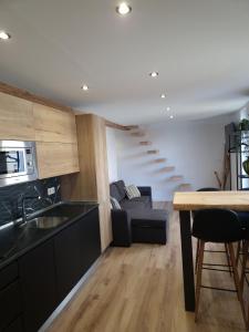 a kitchen and living room with a couch and stairs at Apartamentos Sun si Moon in Santander