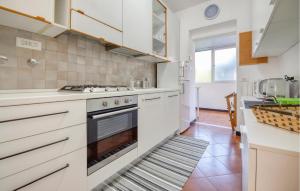 una cucina con mobili bianchi e una stufa di 2 Bedroom Lovely Home In Casarza Ligure a Casarza Ligure