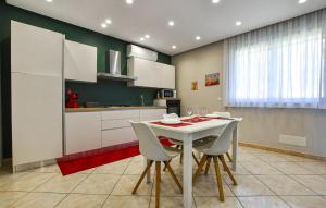 a kitchen with a white table and white cabinets at Pet Friendly Apartment In Monterosso in Fleri
