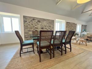 a dining room with a table and four chairs at Refúgio do Ilhéu in Porto Moniz +34 photos