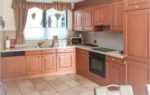 a kitchen with wooden cabinets and a sink and a microwave at 3 Bedroom Gorgeous Home In Lemmer in Lemmer