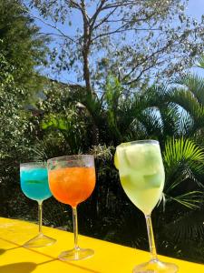 three wine glasses sitting on top of a table at Banana Leaf Eco Hostel in Barra de Guaratiba