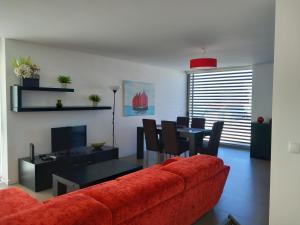 Una sala de estar con un sofá rojo y una mesa. en Silver Coast Heights K, en Lourinhã