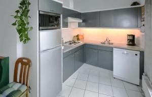 Una cocina con gabinetes azules y un refrigerador blanco. en 2 Bedroom Gorgeous Home In Lemmer, en Lemmer