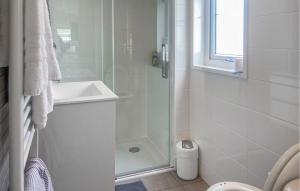 a white bathroom with a shower and a sink at Beautiful Stacaravan In Julianadorp in Julianadorp +10 photos