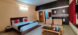 a bedroom with a bed and a table and chairs at CHETAN INN HOTEL in Bhubaneshwar
