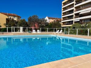a large blue swimming pool next to a building at New apartment with swimming pool in Beaulieu-sur-Mer