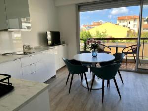 a kitchen with a table and chairs in a kitchen with a window at New apartment with swimming pool in Beaulieu-sur-Mer