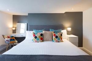 a bedroom with a large white bed with colorful pillows at The Little Mill Inn in New Mills