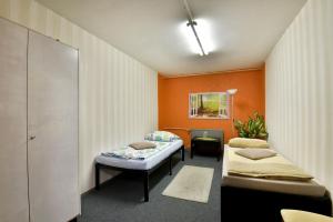Dos camas en una habitación con paredes naranjas. en Monteurwohnung Steinsfeld Suhl, en Suhl