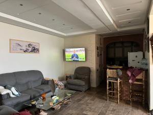 Una sala de estar con un sofá y un televisor de pantalla plana. en Imi Ouaddar, en Agadir nʼ Aït Sa