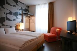 a hotel room with a bed and a television at Hotel Internazionale Bellinzona in Bellinzona
