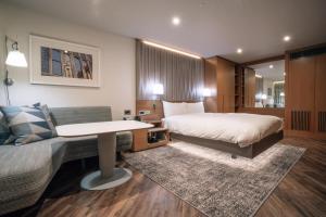 a hotel room with a bed and a couch at Club Quarters Hotel Covent Garden Holborn, London in London