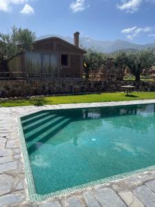 a swimming pool with blue water in front of a house at Bin Jbal Resort in Ouirgane +32 photos