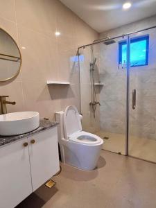 a bathroom with a toilet and a glass shower at Experience Elements CherryBlossoms, Pool,SunRoom in Silang