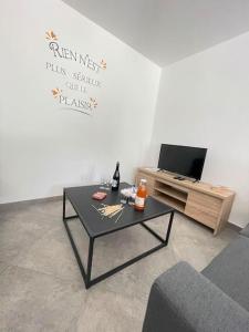 PloërdutNotre essentiel gîte en Bretagne的带咖啡桌和电视的客厅 更多19张照片