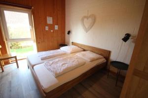 a bedroom with a bed with a heart on the wall at Möwe 14 in Mirow