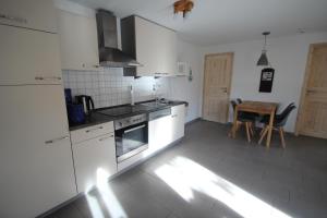 a kitchen with white appliances and a table at Möwe 14 in Mirow