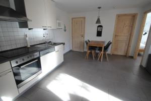 a kitchen with white appliances and a wooden table at Möwe 14 in Mirow +2 photos