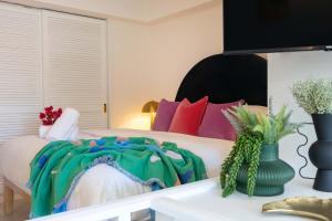 a bedroom with a large bed with colorful pillows at CASA PAPAYA Adults Only Apartment in Port Douglas