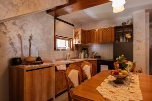 a kitchen with a table with a bowl of fruit on it at Villa Brda in Petrovac na Moru +18 photos