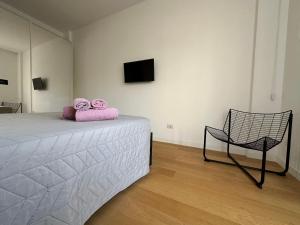 Un dormitorio con una cama y una silla y un televisor. en Suite&Chic Apartment, en Bari