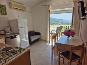 a kitchen and living room with a table and a refrigerator at Apartments Velinka in Rab