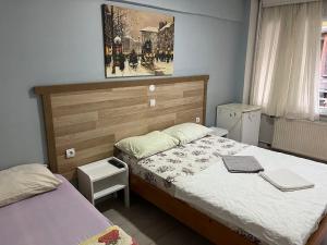a bedroom with two beds and a painting on the wall at Çiğdem Motel Pansiyon & PUB in Termal