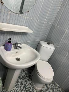 a bathroom with a white toilet and a sink at Çiğdem Motel Pansiyon & PUB in Termal +7 photos
