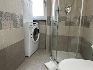 y baño con ducha y lavadora. en Suite&Chic Apartment, en Bari 18 fotos más