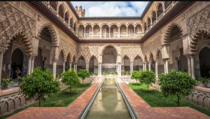 a view of the courtyard of a building with a fountain at Ole triana in Seville