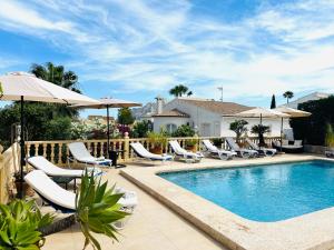 a swimming pool with lounge chairs and umbrellas at Casa Sofia in Calpe