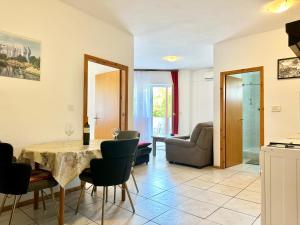 a kitchen and living room with a table and chairs at Apartments Dugonjić in Umag