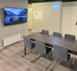 Sala de conferencias con mesa, sillas y TV de pantalla plana en Lilleby Apartment, en Trondheim