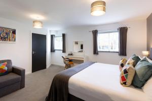 a bedroom with a bed and a chair and a desk at The Little Mill Inn in New Mills