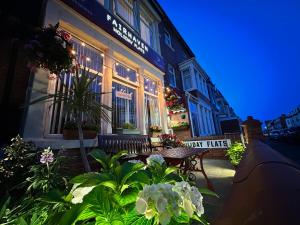 a bench in front of a building with flowers at Fairhaven Holiday Flats in Blackpool