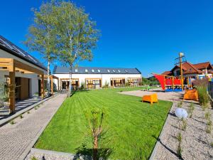 a large yard with a playground in front of a building at Morze Las in Ustka