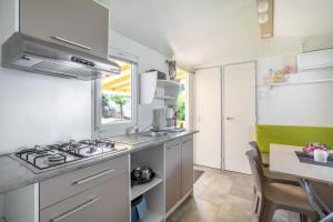 una cocina con fregadero y estufa en Mobilhome 4 personnes, en Argelès-sur-Mer