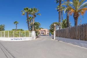una valla junto a una carretera con palmeras en Mobilhome 4 personnes, en Argelès-sur-Mer
